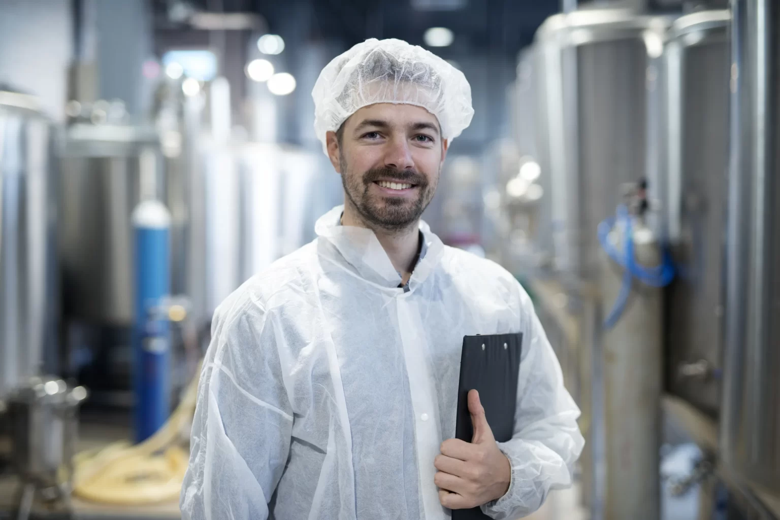 Technicien qualité souriant dans une usine agroalimentaire