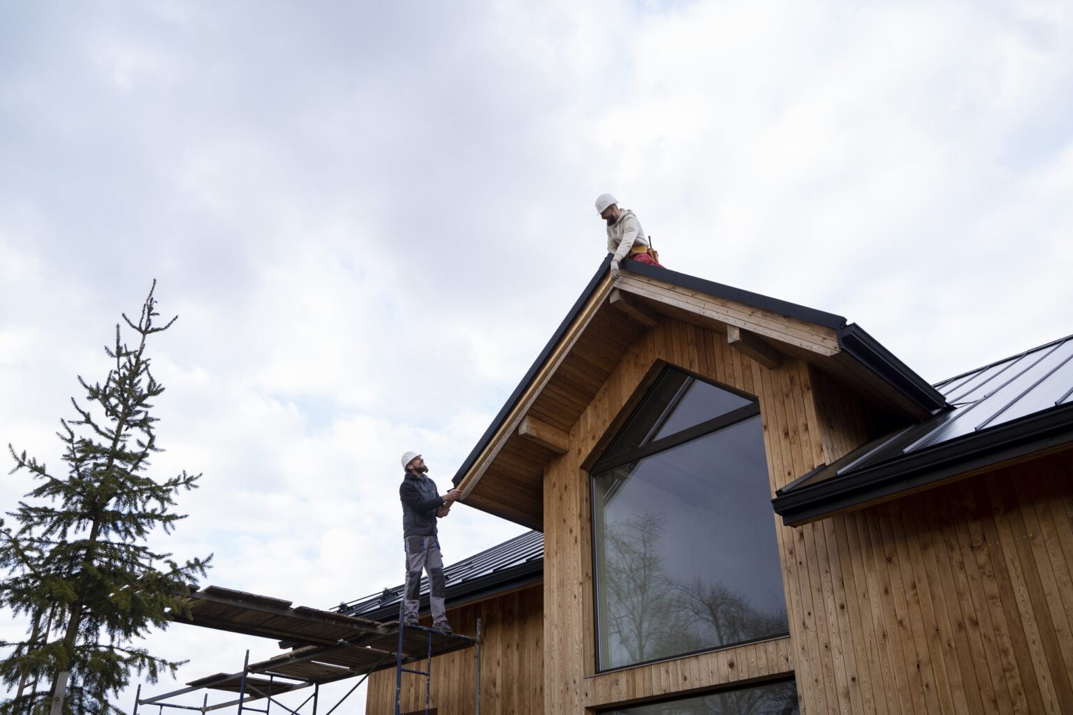 Couvreurs sur la toiture d'une maison bois, assurance décennale couvreur